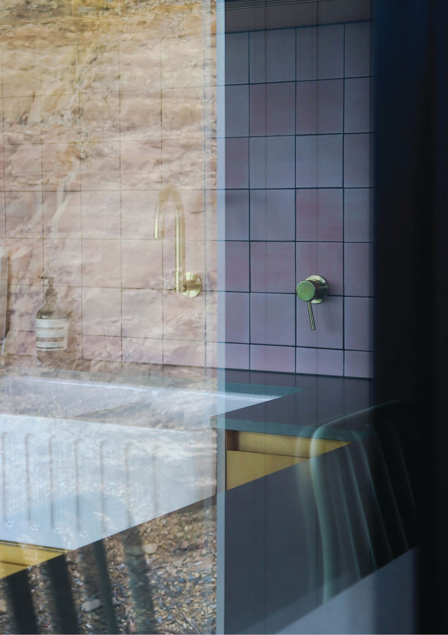 Hotel bathroom sink seen through glass window
